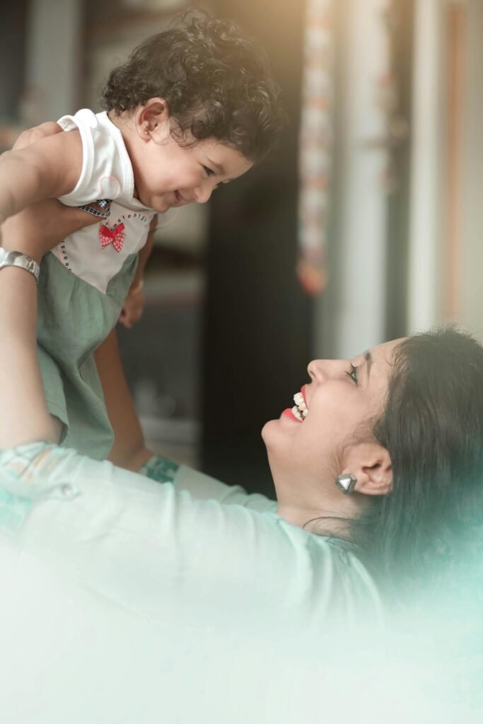 A joyful mother and child sharing a tender moment together indoors, radiating happiness.